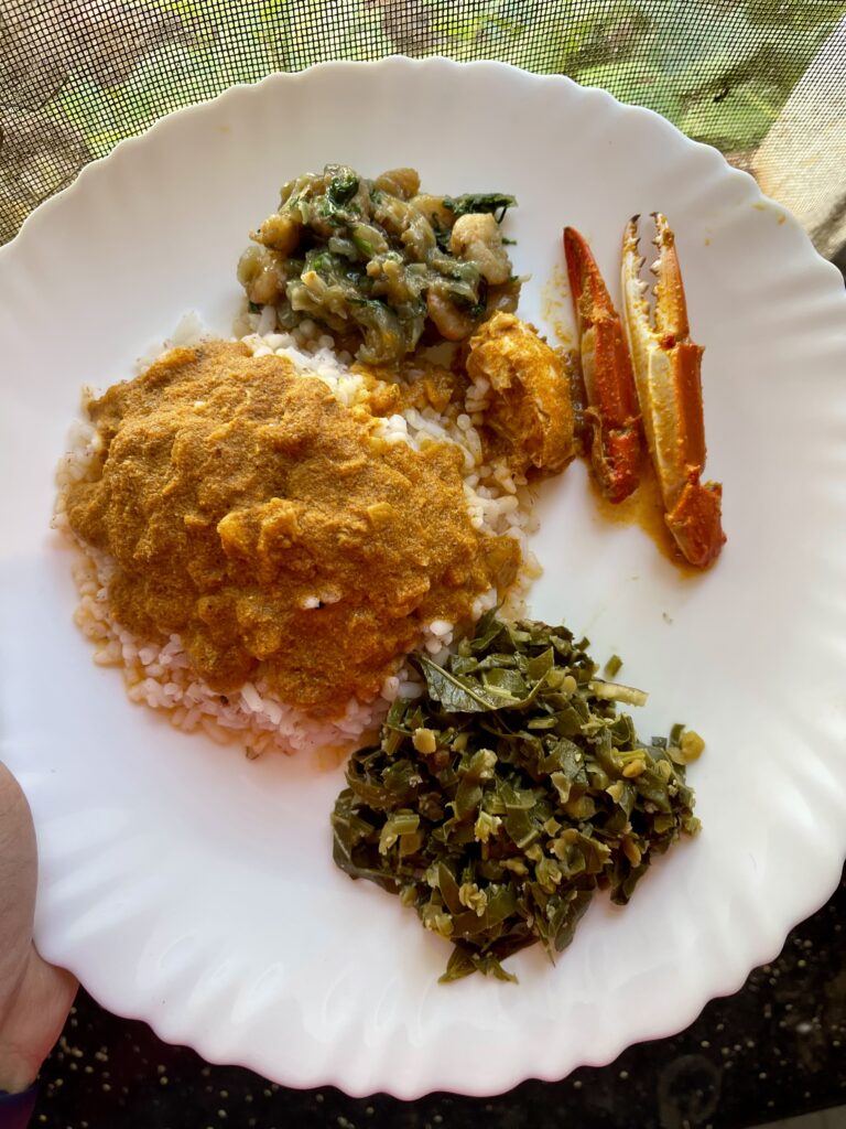 A typical lunch plate in Goa with Goan parboiled rice, crab xec xec curry, local leafy vegetable and prawn chilli fry